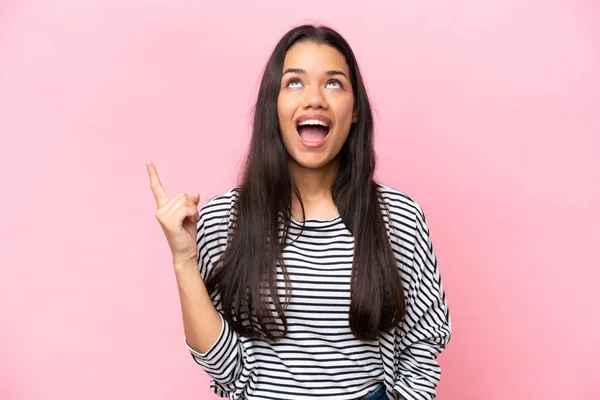 stock image Young Colombian woman isolated on pink background pointing up and surprised