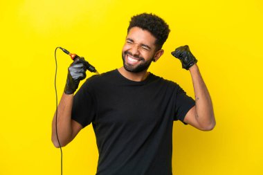 Dövmeli adam Brezilyalı izole edilmiş sarı arka planda zaferi kutluyor.