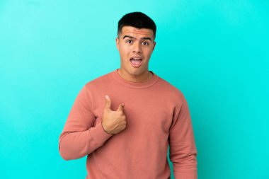 Young handsome man over isolated blue background pointing to oneself