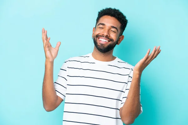 Stock image Young Brazilian man isolated on blue background smiling a lot