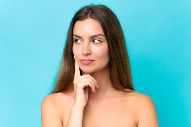 Mavi arka planda soyutlanmış beyaz bir kadın. Portre