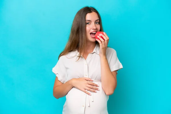 Young Caucasian Woman Isolated Blue Background Pregnant Holding Apple — Fotografie, imagine de stoc