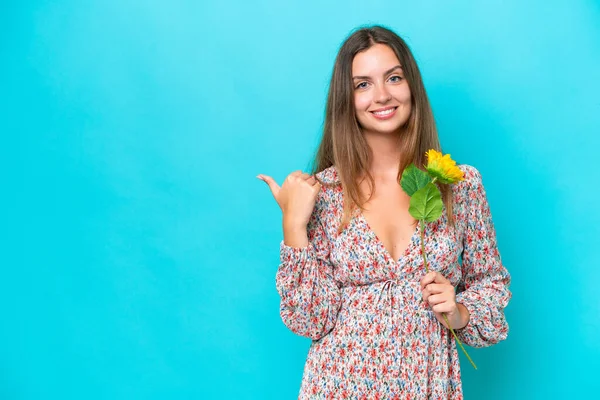 Young Caucasian Woman Holding Sunflower Isolated Blue Background Pointing Side — Stock Photo, Image