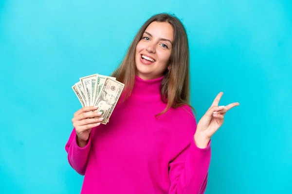 Young Caucasian Woman Taking Lot Money Isolated Blue Background Smiling — Stock Photo, Image