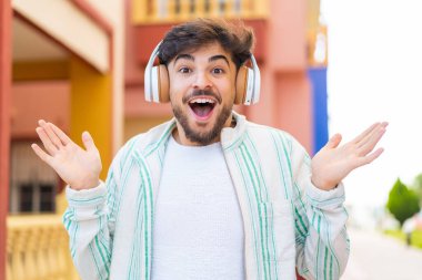 Dışarıdaki yakışıklı Arap şaşırdı ve müzik dinliyor.