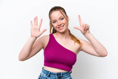 Beyaz arka planda izole edilmiş genç beyaz kız parmaklarıyla yediyi saydı