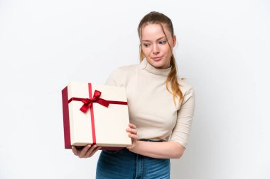 Beyaz arka planda hüzünlü bir ifadeyle izole edilmiş bir hediye tutan beyaz bir kadın.