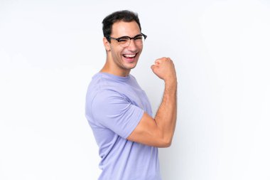 Beyaz arka planda izole edilmiş genç beyaz adam zaferi kutluyor.