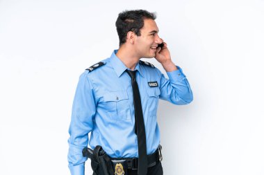 Beyaz arka planda izole edilmiş genç bir beyaz adam cep telefonuyla sohbet ediyor.