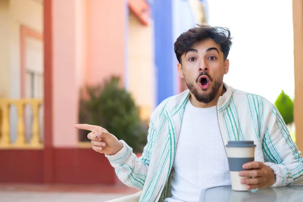 Hezký Arab Muž Drží Odnést Kávu Venku Překvapen Ukazuje Stranou — Stock fotografie