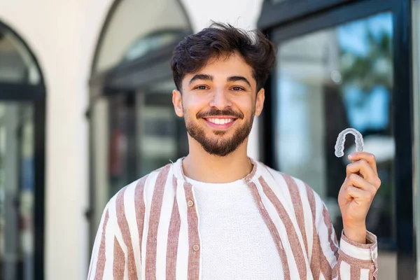 Hezký Arab Muž Drží Neviditelné Rovnátka Venku Usmívá Hodně — Stock fotografie