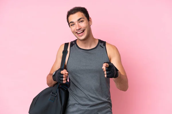 年轻的体育白种人 头戴粉色背景的运动包 面带微笑地指着前方 — 图库照片