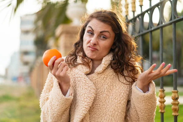 Junge Kaukasische Frau Hält Draußen Eine Orange Und Macht Beim — Stockfoto