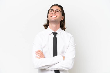 Beyaz arka planda izole edilmiş yakışıklı iş adamı gülümserken yukarı bakıyor