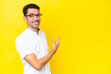 İzole edilmiş sarı arka planı olan yakışıklı bir genç.