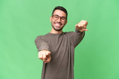 Soyutlanmış geçmişi olan yakışıklı beyaz bir adam mutlu bir ifadeyle öne bakıyor.