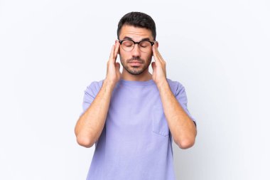 Beyaz arka planda başı ağrıyan genç beyaz bir adam.
