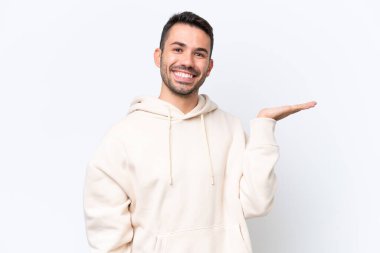 Beyaz arka planda izole edilmiş genç beyaz bir adam bir ilan vermek için avucunun içinde hayali bir fotokopi makinesi tutuyor.