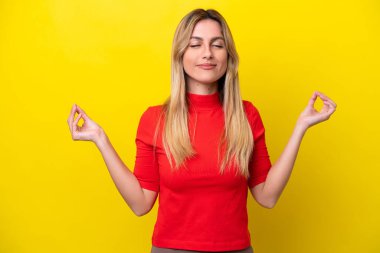 Young Uruguayan woman isolated on yellow background in zen pose