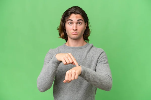 stock image Young caucasian man isolated on green chroma background making the gesture of being late