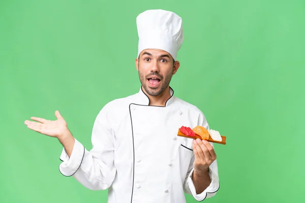 Young Caucasian Chef Holding Sushi Isolated Background Shocked Facial Expression — Stock Photo, Image