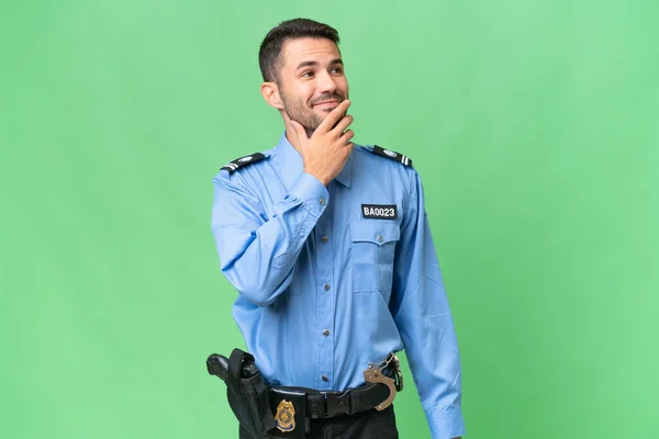 Молодий Поліцейський Білий Чоловік Над Ізольованим Тлом Дивлячись Вгору Посміхаючись — стокове фото