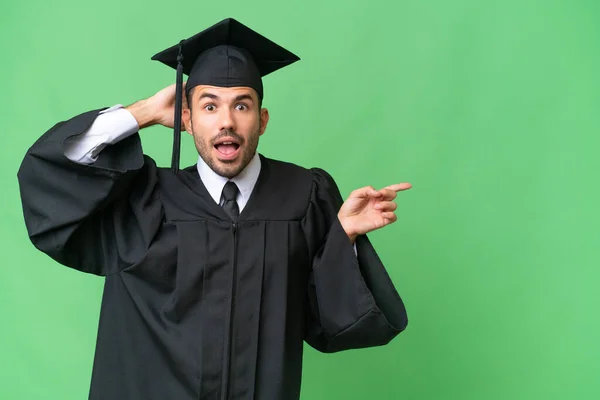 Young University Graduate Man Isolated Background Surprised Pointing Finger Side — Stock Photo, Image
