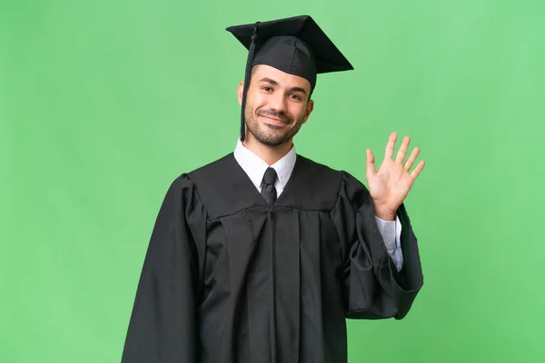 Young University Graduate Man Isolated Background Saluting Hand Happy Expression — Stock Photo, Image