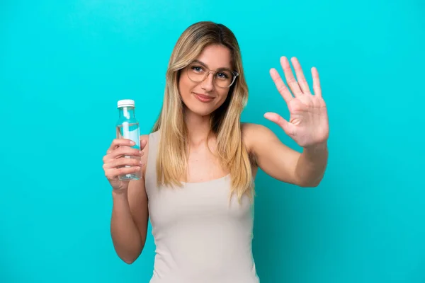 Ung Uruguayansk Kvinne Med Flaske Vann Isolert Blå Bakgrunn Teller – stockfoto