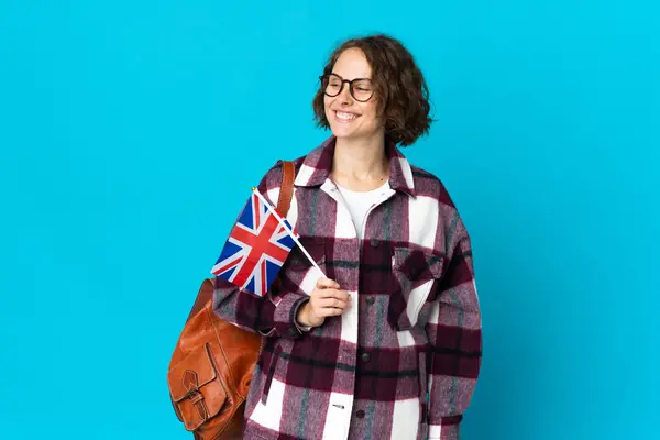 Młoda Angielka Trzymająca Flagę Zjednoczonego Królestwa Niebieskim Tle Patrząca Boku — Zdjęcie stockowe