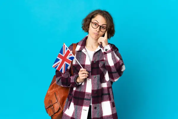 Młoda Angielka Trzymająca Flagę Zjednoczonego Królestwa Niebieskim Tle Myśląca Pomyśle — Zdjęcie stockowe