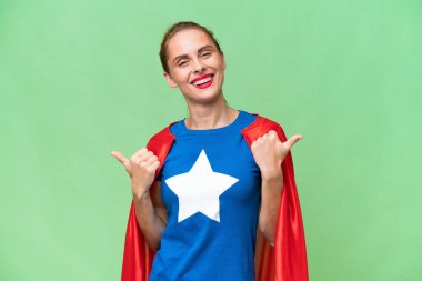 Süper kahraman beyaz kadın izole edilmiş arka planda. Baş parmakları havada ve gülümsüyor.