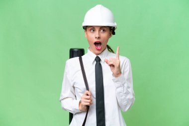 Miğferli genç bir mimar, izole edilmiş arka planda planları tutuyor.