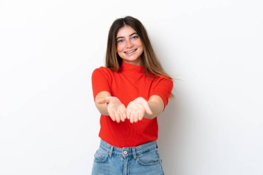 Beyaz arka planda izole edilmiş genç beyaz kadın bir ilan vermek için avucunun içinde hayali bir fotokopi makinesi tutuyor.