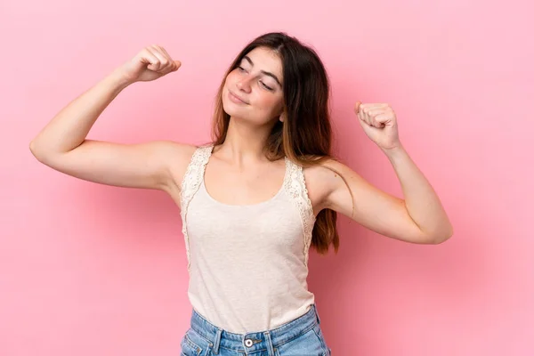 stock image Young caucasian woman isolated on pink background doing strong gesture