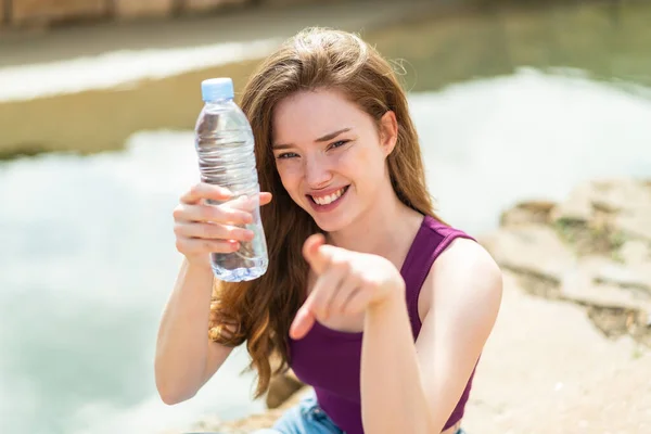 Jonge Roodharige Vrouw Met Een Fles Water Buiten Wijst Naar — Stockfoto