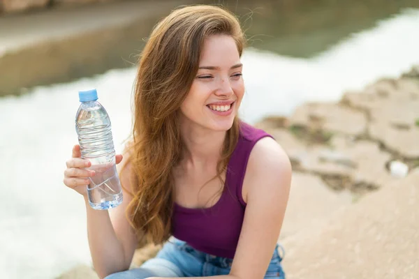 Jonge Roodharige Vrouw Met Een Fles Water Buitenlucht Kijken Omhoog — Stockfoto