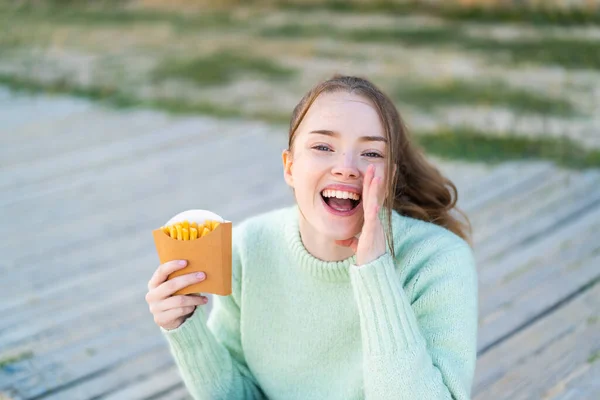 Young Pretty Girl Holding Fried Chips Outdoors Shouting Mouth Wide — Stock Photo, Image