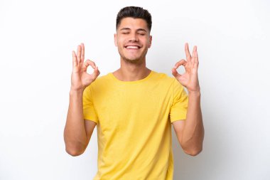 Beyaz arka planda Zen pozisyonunda beyaz tenli genç bir adam