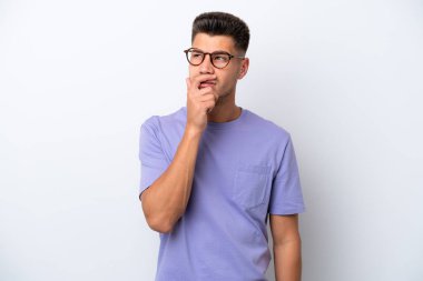 Beyaz arka planda izole edilmiş genç beyaz bir adam. Şüpheleri var ve kafası karışmış bir yüz ifadesi var.