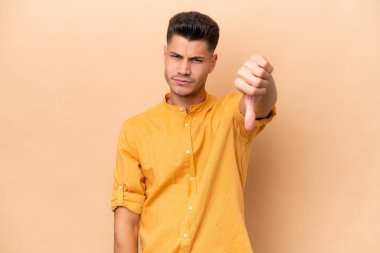 Beyazlı genç bir adam bej arka planda izole edilmiş.