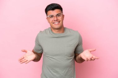 Beyaz tenli yakışıklı bir adam pembe arka planda izole edilmiş mutlu ve gülümsüyor.