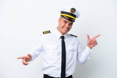 Beyaz arka planda izole edilmiş beyaz uçağın pilotu parmak uçlarını gösteriyor ve mutlu.