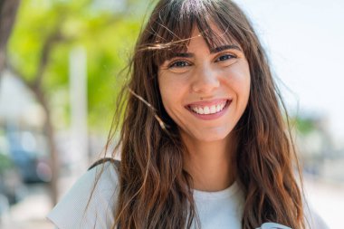 Açık havada genç bir kadın Neşeli bir ifadeyle