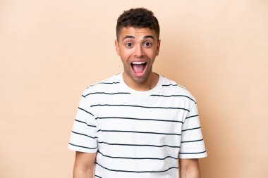 Young Brazilian man isolated on beige background with surprise facial expression