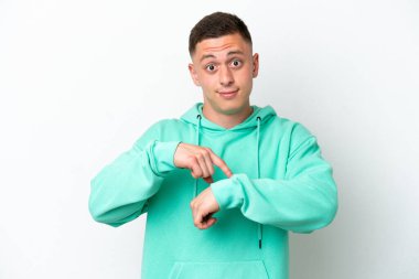 Genç Brezilyalı adam beyaz arka planda izole edilmiş, geç kalma jesti yapıyor.