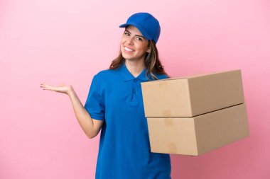 Pembe arka planda izole edilmiş İtalyan kadın. Davet edildiği için ellerini yana uzatıyor.