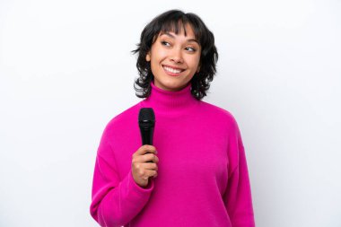 Genç Arjantinli şarkıcı kadın, beyaz arka planda izole edilmiş bir şekilde bir fikir ararken,