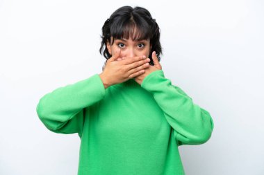Arjantinli genç bir kadın beyaz arka planda izole edilmiş, ağzı elleriyle kapatıyor.