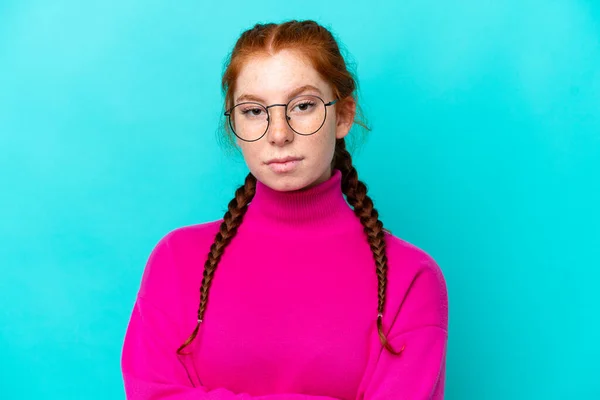 Młoda Rudowłosa Kobieta Odizolowana Niebieskim Tle Skrzyżowanymi Okularami Ramionami — Zdjęcie stockowe